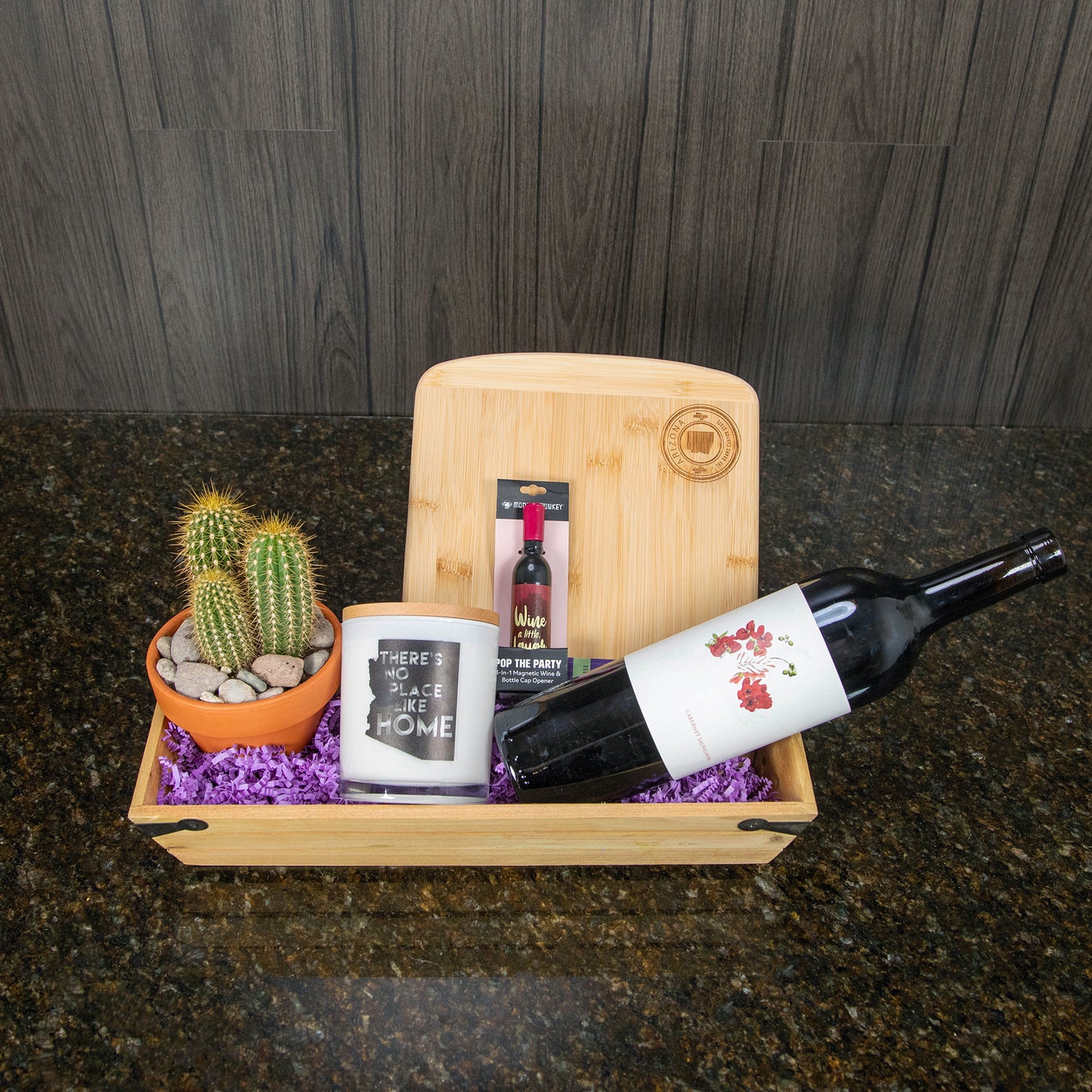 a gift basket with a small cactus, wine, and Arizona themed gifts