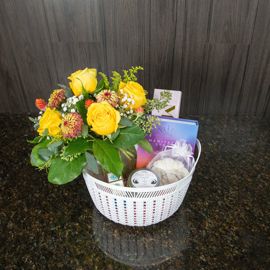 a gift basket containing a flower arrangement and meditation themed gifts